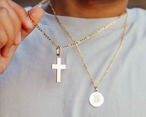 figaro chains, solid gold letter pendant, and a gold cross 