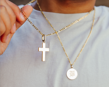 figaro chains, solid gold letter pendant, and a gold cross 